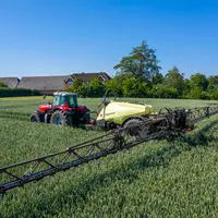 Pulvérisateur traîné Hardi Navigator en finition Centura Line au travail avec tracteur Masssey Ferguson