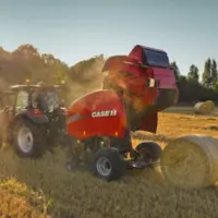Presse à balles rondes Case IH RB 456 au travail avec un tracteur Case IH