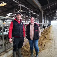 Deux éleveurs dans leur bâtiment de stabulation.