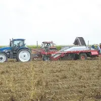 L'arracheuse de pommes de terre avec à son bord les salariés.