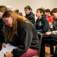 Un groupe d'élèves prend des notes.