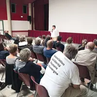 Un groupe de bénévoles et d'agriculteurs assistent à une projection.