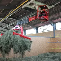 Le foin est amené à la ferme en autochargeuse puis repris à la griffe pour être stocké dans la cellule de séchage.
