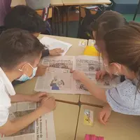 Des élèves d'une classe de CE2 à St Etienne dans la Loire feuillettent des journaux et magazines.