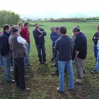 Réunion technique autour d’un champ de céréales en agriculture biologique.