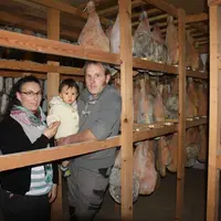 Ludivine et Sébastien Denis avec leur petit dernier dans les séchoirs de la ferme.