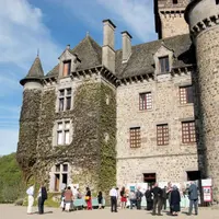 Châtelains et guides à la rencontre d’autres acteurs touristiques, au pied du donjon de Pesteils, à Polminhac. 
