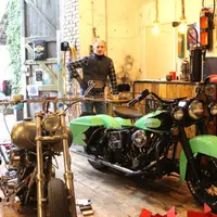 Éric Poli dans son atelier de Polminhac avec quelques-unes de ses Harley.