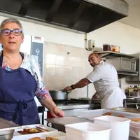 En cuisine, Hélène et Henri s'affairent : chaque jour, ils préparent des plateaux repas à emporter.
