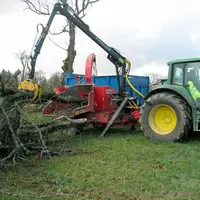 Le conducteur saisit les branches au moyen d’un grappin et les insère dans le rotor qui les déchiquète au moyen des deux rouleaux crénelés. Le produit