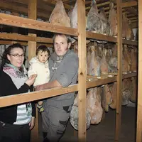 Ludivine et Sébastien Denis avec leur petit dernier dans les séchoirs de la ferme.