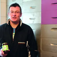 Alexandre Louche, dans sa miellerie, avec son miel médaillé d'argent au concours des miels de France.