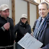 Philippe Castanet, le préfet de Lozère, tient la pochette de la pétition et la montre au photographe. À ces côtés, un adhérent du collectif contre les