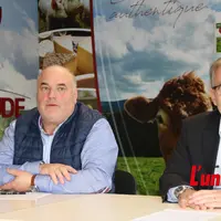 Deux hommes devant les affiches du groupe Altitude.