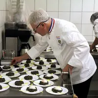 Christian Têtedoie en pleine préparation d'une assiette de lentilles et endives