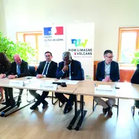 Un groupe de personnes bien habillées assis derrière des tables