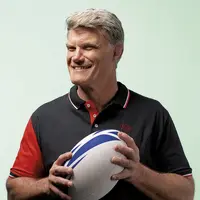 Fabien Pelous, ancien capitaine de l'équipe de france de rugby à XV, tient un ballon de rugby