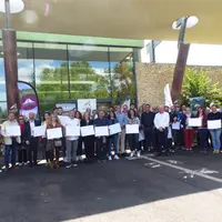 Un groupe de personnes devant un bâtiment tenant des pancartes