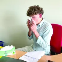 un jeune garçon qui se mouche