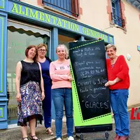 Quatre femmes devant un commerce d'alimentation.