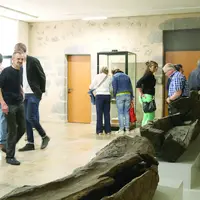 Public dans le musée avec sarcophages ouverts
