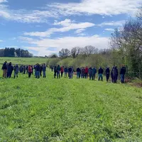 Groupe de personnes visitant un pré.