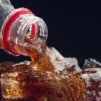 bouteille versant du soda dans un verre