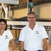 Chantal Rech et Jean-Pierre Constans, les co-directeurs du moulin de Colagne devant la meule de pierre en silex.