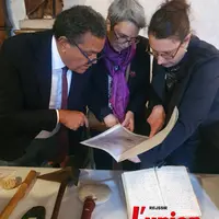 Trois personnes observent un document