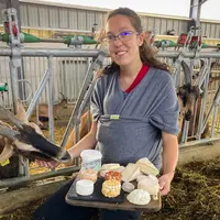 Une éleveuse présente ses fromage dans une chèvrerie