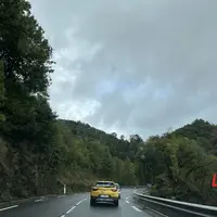 Voiture jaune sur une route à l'approche d'un virage