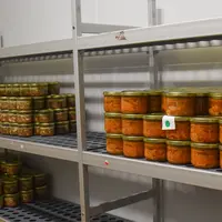 Des étagères métalliques avec des bocaux de plats préparés.