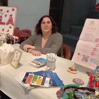 Jeune femme tenant un stand au profit de la recherche contre la maladie de Charcot