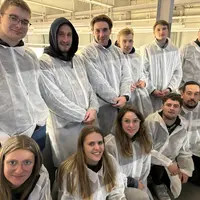 Groupe de jeunes gens en visite à Rungis, revêtus de blouse de protection