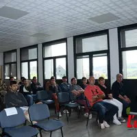Homme debout intervant devant une assemblée de jeunes éleveurs dans une salle
