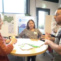 Trois personnes parlent autour d'une table