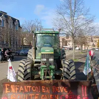 Un tracteur avec un tag "enfant on en rêve, adulte on en crève JA03" est garé devant la préfecture de l'Allier