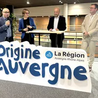 quatre personne derrière uun panneau, l'une d'entres elles tient un micro