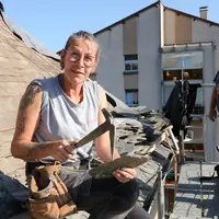 Une femme avec un marteau avec un homme sur sa gauche