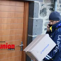Le facteur avec un colis devant une porte en bois.