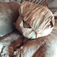 Des ballots de laine de mouton sont stockés dans un bâtiment.