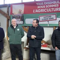 Un groupe de quatre personnes se tient devant une banderole syndicale