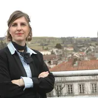Une jeune femme avec l'église Saint-Géraud en fond