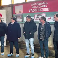 Un groupe est debout devant des affiches électorales agricoles
