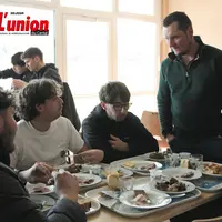 Un produicteur et des élèves en train de manger autour d'une table.