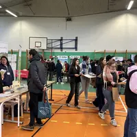 Des stands d'exposition dans un gymnase d'établissement scolaire