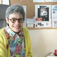 Une dame souriante assise à son bureau