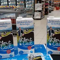 Briques de lait Mont Lait sur une table dans un supermarché.