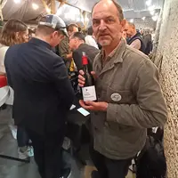 un homme tient une bouteille de vin