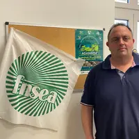 un homme a coté d'un drapeau FNSEA